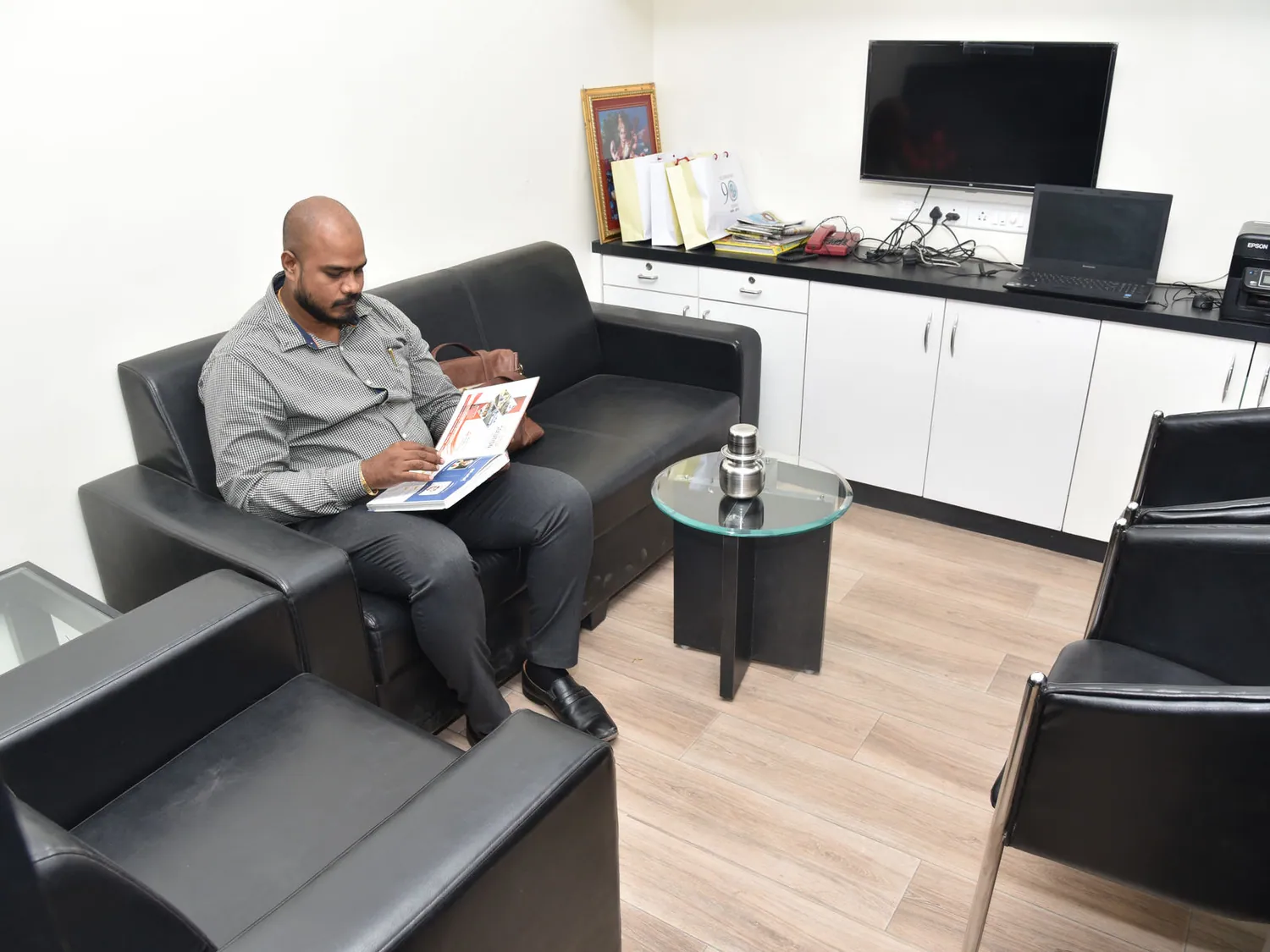 A visitor reading a booklet on the sofa in the MVEM reception