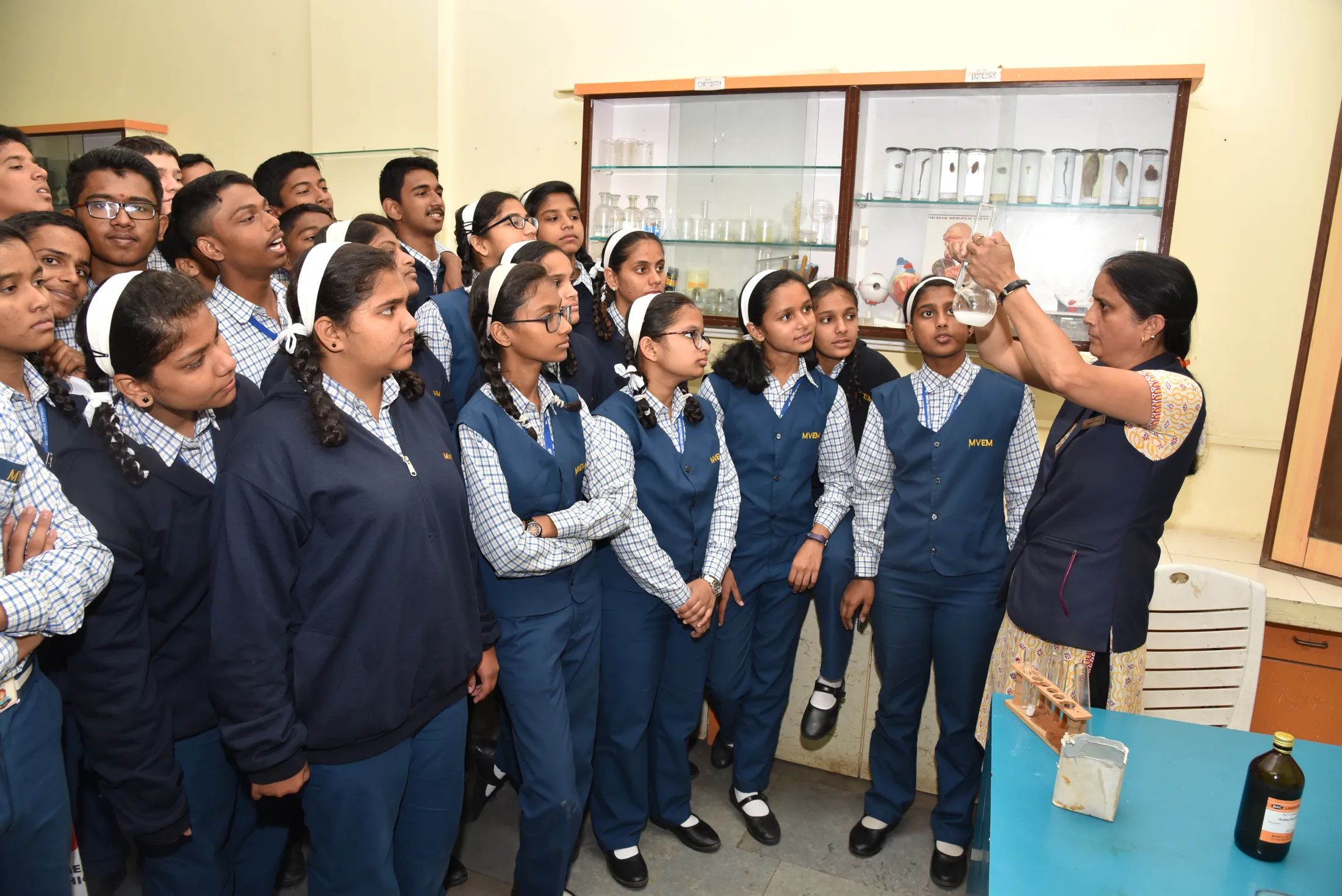 Secondary students gathered around a science demonstration