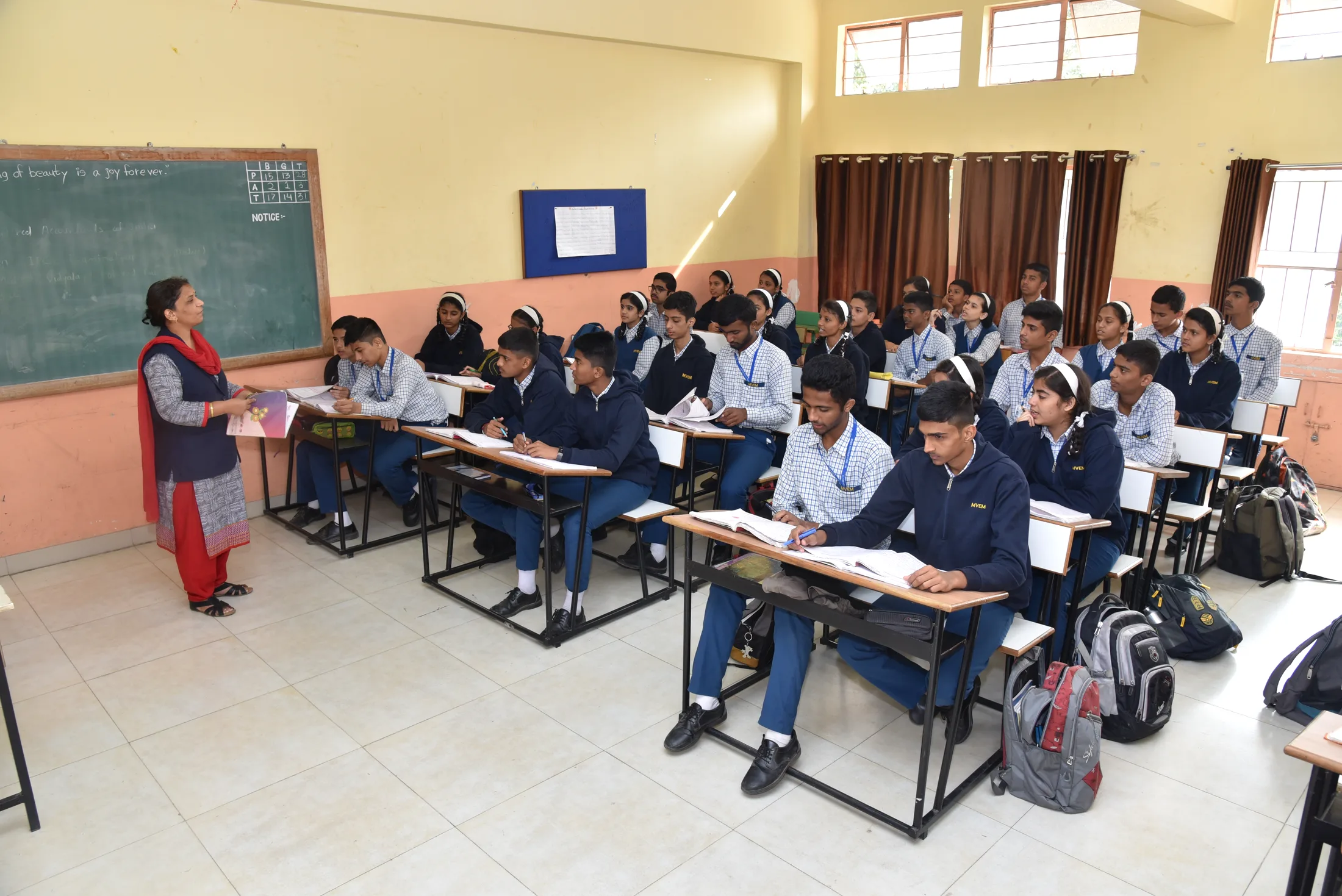 A class at their desks, the teacher at the board
